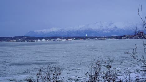 Icey-river-view-of-Anchorage-Alaska-in-the-winter-with-a-mountain-in-the-background