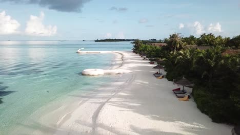 Drohne-Fliegt-über-Der-Küste-Der-Malediven-Insel,-Blaues-Wasser,-Weißer-Sand,-Grüne-Palmen-Und-Villen