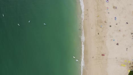 Top-Down-View-Of-Turquoise-Ocean-And-Sandy-Beach-With-Tourists-Enjoying-In-St-Ives,-Cornwall,-England---drone-shot