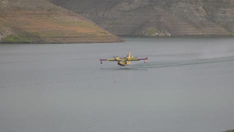 Avión-De-Extinción-De-Incendios-Waterbomber-Recogiendo-Agua-Del-Lago