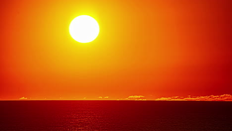 Bright-shining-sun-setting-behind-ocean-horizon-during-golden-sunset-at-sea---time-lapse