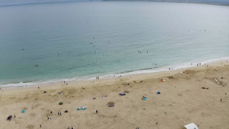 Aerial-View-Of-People-Having-Fun-On-The-Beach-In-St-Ives,-Cornwall,-England---drone-shot
