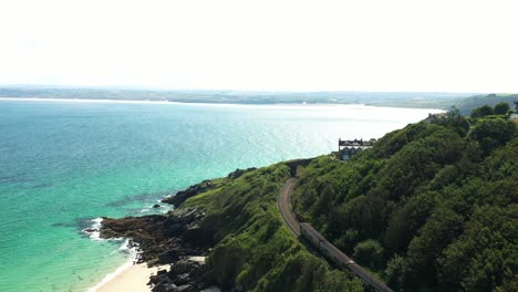 Aerial-View-Of-Train-On-The-St-Ives-Coastline-At-Carbis-Bay-In-Cornwall,-England---drone-shot