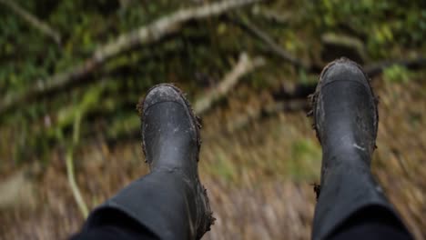 Female-Feet-In-Dirty-Rubber-Boots-While-Swinging-In-The-Forest
