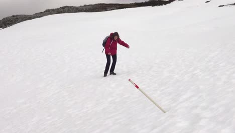 Hiking-lady-makes-slow-progress-and-nearly-slips-on-frozen-snow-covered-hillside