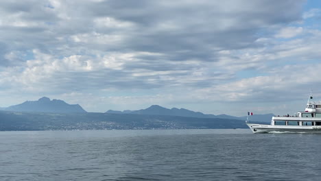 Ein-Touristisches-Boot-überquert-Den-Rahmen-Und-Fährt-Auf-Dem-Genfer-See,-Dem-Größten-See-Westeuropas,-Schöne-Aussicht-Auf-Die-Französischen-Alpen