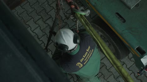 Arbeiter-In-Einem-Helm,-Der-Stahlkabel-Für-Den-Transport-Großer-Maschinen-Festzieht,-Draufsicht