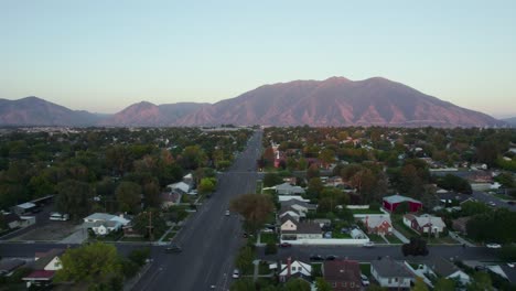 Suburban-City-Streets-of-Spanish-Fork-City-with-Utah's-Wasatch-Mountains-at-Sunset,-Aerial-Establishing