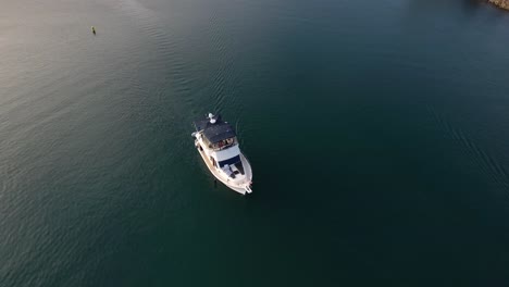 Motorbootfahrt-Entlang-Des-Dana-Point-Yachthafens,-Blick-Von-Oben-Nach-Unten-Auf-Ein-Weißes-Schiff-In-Tiefblauem-Wasser