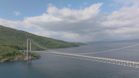 Skjom-suspension-bridge-with-tourist-campers-crossing-above-water,-view-of-Ofotfjord