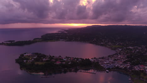 Luftaufnahme-Des-Sonnenaufgangs-über-Dem-Osthafen-In-Port-Antonio-In-Jamaika-Mit-Rosa-Und-Violetten-Himmeln,-Die-Sich-Vom-Ozean-Spiegeln