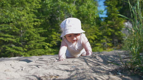 Cute-little-baby-child-crawling-and-playing-in-sand-outdoors