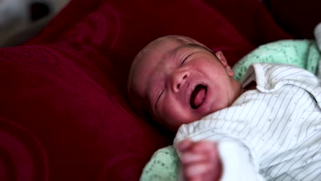 Asiatisches-Indisches-Neugeborenes-Baby,-Das-Sich-Bewegt,-Während-Es-Auf-Dem-Rücken-Auf-Einem-Bett-Liegt