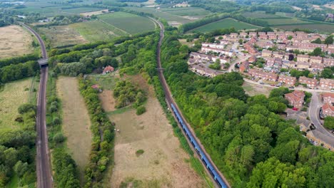 Arial-shot-of-a-train-going-passed-houses-and-heading-away-from-Canterbury-and-towards-the-A2-dual-carriageway