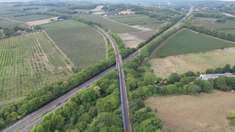 Aerial-shot-following-a-train-leaving-Canterbury-and-going-over-the-A2-Dual-Carriage-way