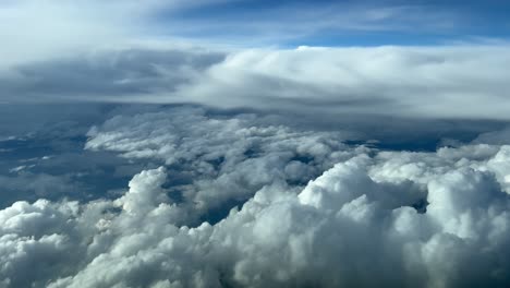Impresionante-Vista-Aérea-Tomada-Desde-La-Cabina-De-Un-Jet-Durante-El-Nivel-De-Crucero-En-Un-Cielo-Turbulento-Lleno-De-Cúmulos-Y-Cumulonimbos