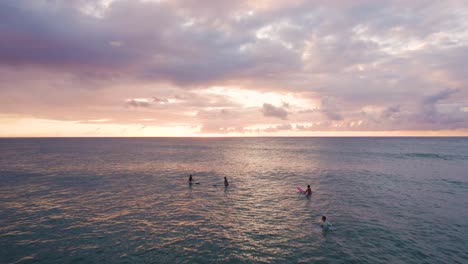 Surfer,-Die-Bei-Sonnenuntergang-Im-Ozeanwasser-In-Oahu-Chillen,-Hawaii,-überführung
