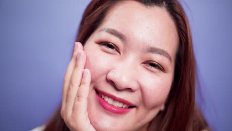 Nahaufnahme-Porträt-Einer-Attraktiven-Asiatischen-Frau,-Die-Glücklich-Lächelnd-Und-Selbstbewusst-Fröhlich-Mit-Violettem-Hintergrund-Mit-Weichem-Fokus-Ist-1