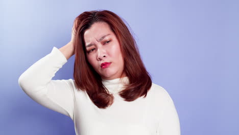 Confused-puzzled-upset-young-Asian-woman-standing-isolated-over-a-violet-background