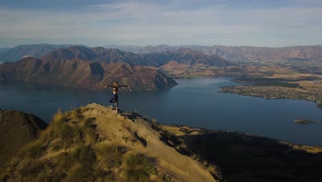 A-tall-blonde-woman-is-doing-yoga-on-a-mountain-peak-in-New-Zealand