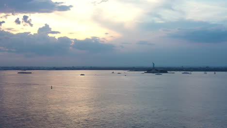 Panning-shot-across-New-York-Harbor-at-dramatic-sunset-with-the-Statue-of-Liberty-in-the-distance