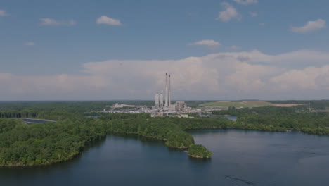 Aerial-rotation-and-slow-zoom-in-on-a-power-plant-in-hazy-afternoon-clouds-on-a-lake