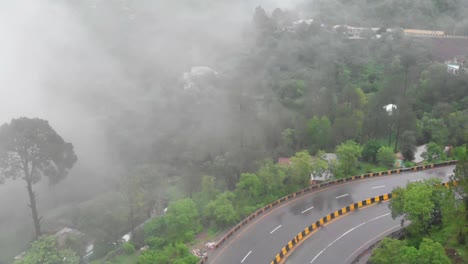 Aerial-View-Of-Curve-Of-Muree-Expressway-Beside-Misty-Foggy-Trees
