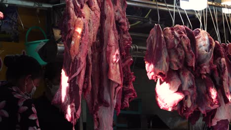 Carne-Cruda-Colgada-En-Una-Carnicería-Asiática-En-Un-Mercado-Húmedo