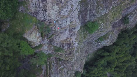Ascending-wide-aerial-view-from-drone-of-people-climbing-mountain-at-high-altitude