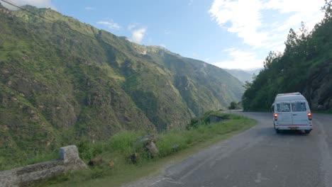 Force-traveler-riding-through-Kinnaur-Shimla-road-carved-through-mountain-and-steep-rocky-cliff-in-the-Himalaya