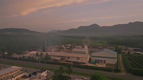 Aerial-view-pf-traffic-pm-highway-and-fumes-of-factory-rising-into-sky-early-in-the-morning---Villa-Altagracia,Dominican-Republic