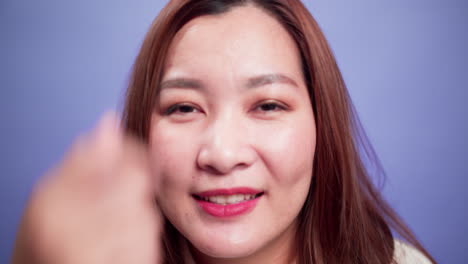 Nahaufnahme-Porträt-Einer-Attraktiven-Asiatischen-Frau,-Die-Glücklich-Lächelnd-Und-Selbstbewusst-Fröhlich-Mit-Violettem-Hintergrund-Mit-Weichem-Fokus-Ist