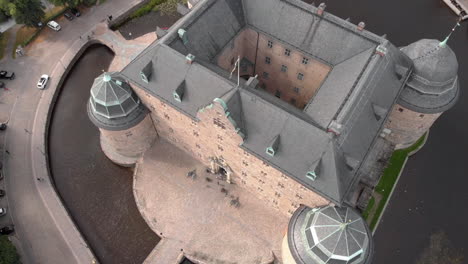 Wide-angle-shot-from-a-drone-flying-over-and-panning-down-on-Örebro-castle-in-Sweden