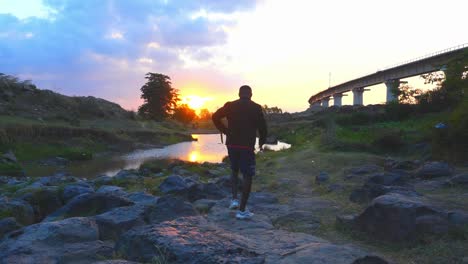 Young-Male-Walking-To-The-River-At-Sunset