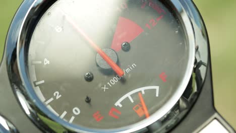 Close-up-of-analog-motorcycle-tachometer-with-reflection
