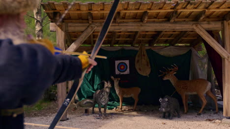 Man-using-a-Viking-bow-shoots-an-arrow-into-a-practice-deer-target-in-slow-motion