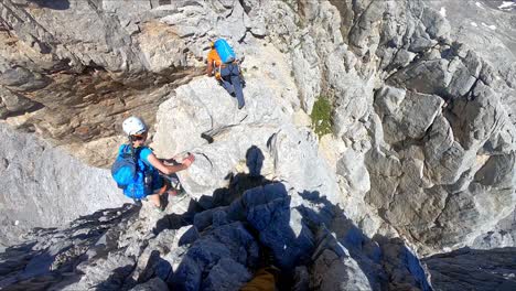 A-girl-and-a-boy-mountaineer-climbing-in-very-high-rocks-un-peaks-of-europe