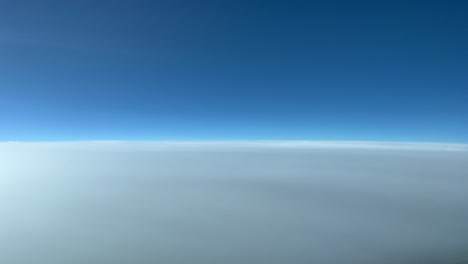 Vista-Aérea-Sobrevolando-Una-Capa-Muy-Alta-De-Nubes-Estratos-A-12000-Metros-De-Altura-Desde-La-Cabina-De-Un-Jet