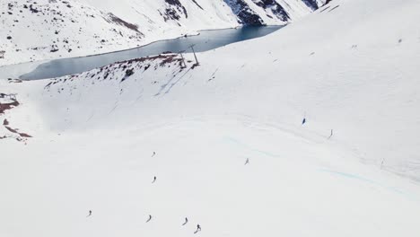 Aerial-View-Of-Skiers-At-Portillo-Ski-Resort-In-The-Andes-Mountains-Of-Chile---drone-shot