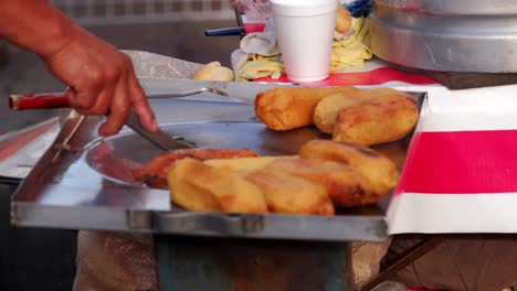 Frittieren-Von-Tamales-Mexikanischer-Streetfood-verkäufer-Handrühren-Von-Maiskrapfen-In-Heißem-öl