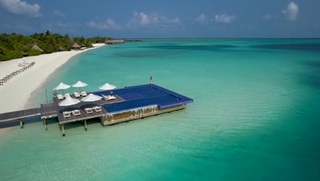 Frau-Im-Roten-Badeanzug,-Der-Am-Rand-Des-überwasser-infinity-pools-Im-Luxusresort-Auf-Den-Malediven-Steht