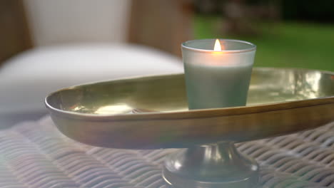 Close-up-of-a-candle-burning-at-a-table-with-outdoor-seating-at-a-bar,-hotel,-wedding,-or-fancy-restaurant