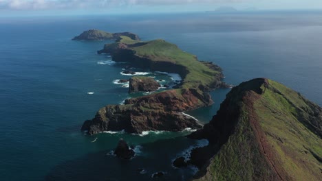 Drone-shot-of-the-islands-in-Madeira-with-a-small-trail-leading-up-to-the-peak-of-a-cliff