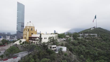 Disparo-De-Drones-En-El-Día-Nublado-De-La-Mañana-En-Hasta-Bandera-Sobre-El-Cerro-Obispado-En-La-Ciudad-De-Monterrey,-México