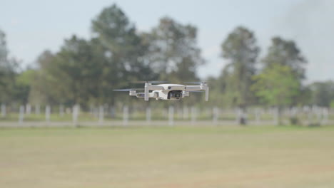 Drone-flying-outdoor-hovering-mid-air,-spinning-on-its-axis-in-a-open-country-side