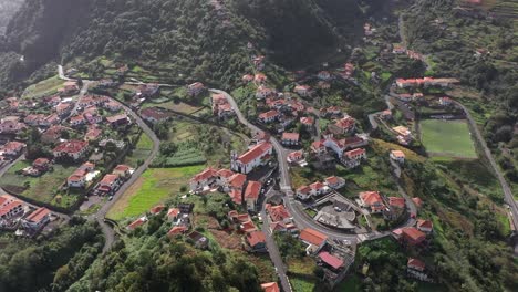 Drohnenaufnahme-Eines-Kleinen-Dorfes-In-Madeira-Mit-Kleinen-Straßen-Und-Feldern-An-Der-Seite-Des-Berges