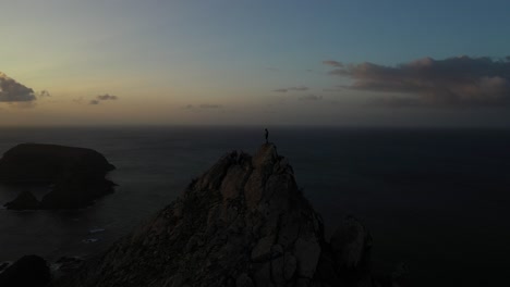Single-person-standing-alone-on-top-of-a-mountain-in-Porto-Santo,-Madeira-during-sunset