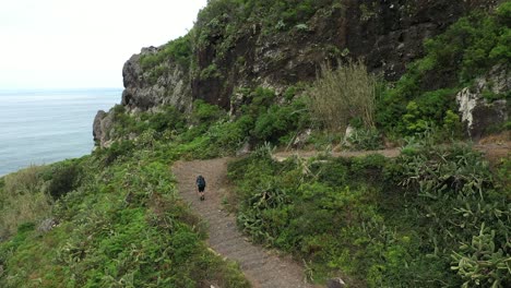 A-single-man-is-hiking-up-the-trail-on-the-side-of-the-mountain-in-Madeira