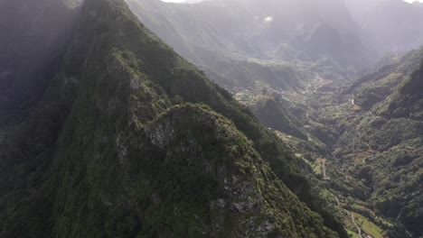 Kreisende-Drohnenaufnahme,-Die-Sich-Auf-Den-Kamm-Eines-Berges-Mit-Zwei-Seiten-Mit-Häusern-Von-Dörfern-In-Madeira-Konzentriert