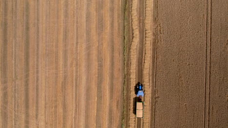 Aerial-Overhead-View-Of-Tractor-Pulling-Trailed-Loaded-With-Wheat
